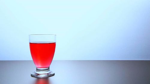 Close-up of red wine against blue background