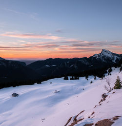 Scenic view of snow covered mountains against sky during sunset