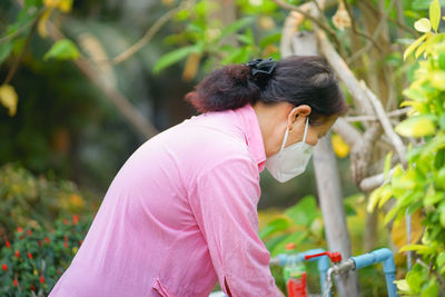Side view of woman against plants