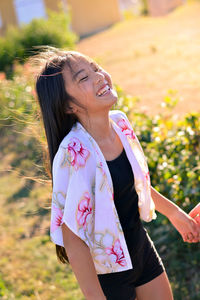 Midsection of a smiling young woman standing outdoors