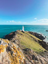 Lighthouse by sea against sky