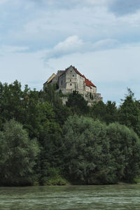 River amidst trees and buildings against sky