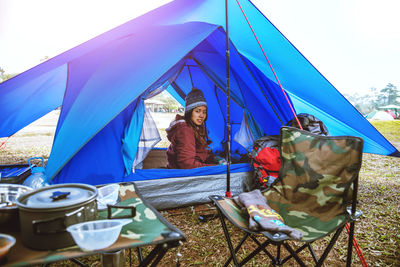 Portrait of young woman sitting in tent