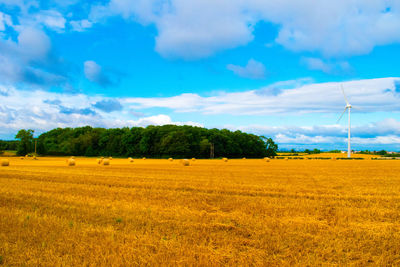 Scenic view of field against cloudy sky