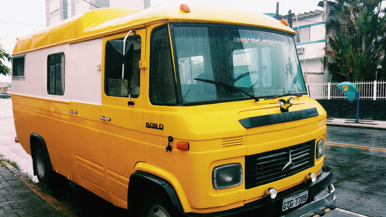 yellow, transportation, building exterior, architecture, mode of transport, built structure, land vehicle, car, public transportation, city, street, outdoors, travel, incidental people, building, orange color, day, arch, no people, train - vehicle