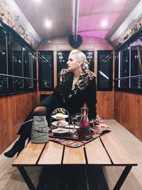 Woman sitting on table in restaurant