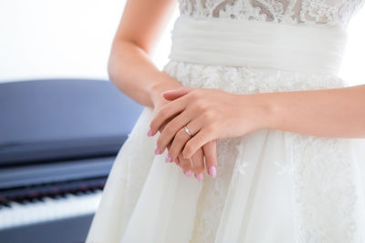 Midsection of bride in dress standing at ceremony