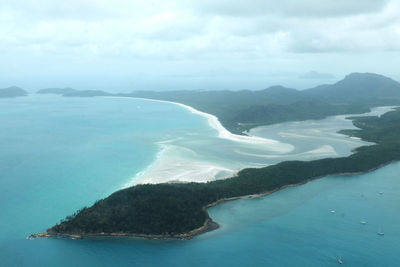 Aerial view of sea and mountains against sky