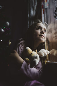 Portrait of young woman with toy at home