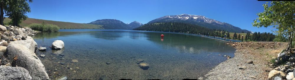 Scenic view of lake against clear blue sky