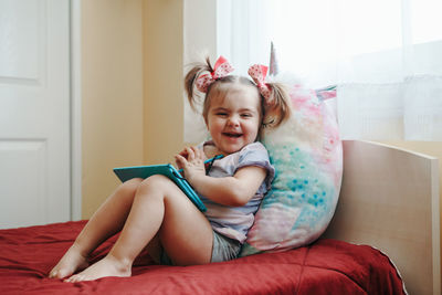 Cute girl sitting on bed at home