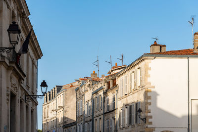 Low angle view of buildings against clear blue sky