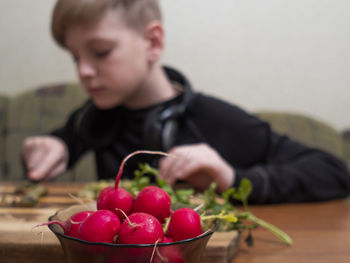 Midsection of man holding strawberry on table