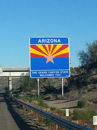 Road sign against clear blue sky