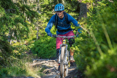 Man riding a mountain bike on footpath in the austrian alps, saalbach, austria