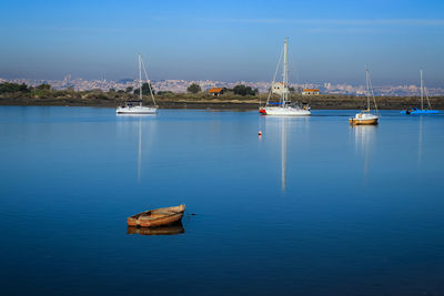 Sailboats moored on river against sky