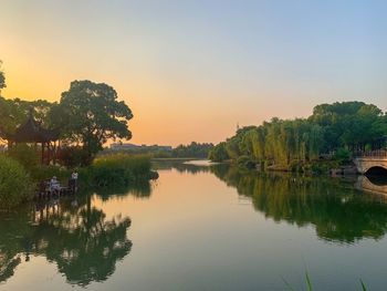 Scenic view of lake against clear sky at sunset