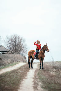 Man riding horse on motorcycle against sky