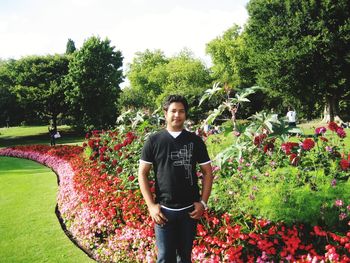 Portrait of young man standing against trees