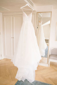 A white wedding dress hanged on the hanger. buying a wedding dress.