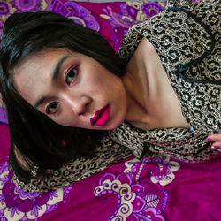 Portrait of beautiful woman lying on bed