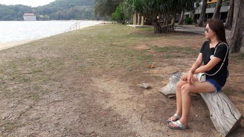 Side view of young woman sitting in water