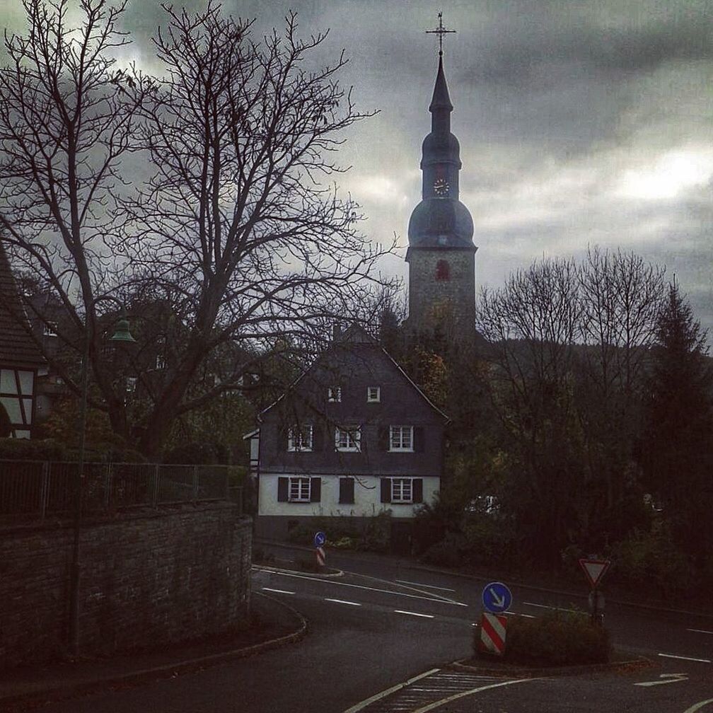 building exterior, architecture, built structure, tree, sky, tower, transportation, street, city, road, bare tree, car, land vehicle, travel, travel destinations, church, tall - high, incidental people, the way forward, religion