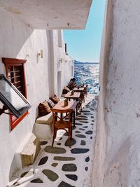 Chairs and table by sea against buildings