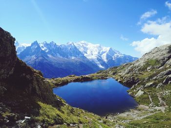 Scenic view of snowcapped mountains against blue sky