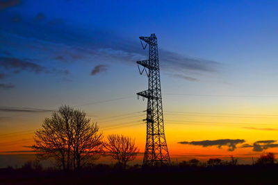 Low angle view of silhouette electricity pylon against sky during sunset