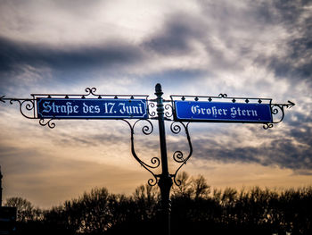 Close-up of road sign against sky