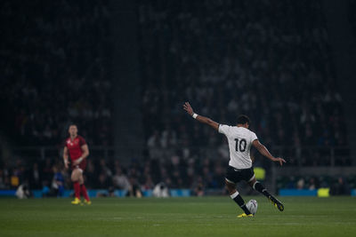 Person standing on soccer field at night