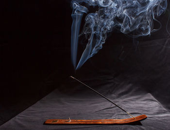 Close-up of smoke emitting from cigarette on table