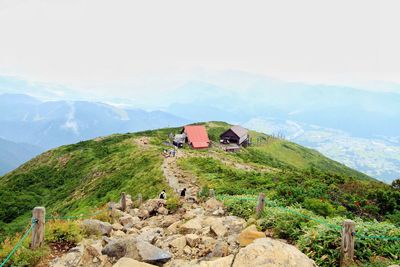 High angle view of houses on green mountain in foggy weather