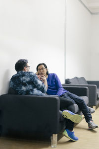 Two office workers sitting on sofa and talking