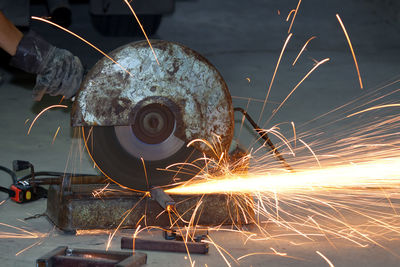 Cropped hand of worker cutting metal