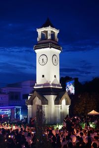 People at temple against sky at night