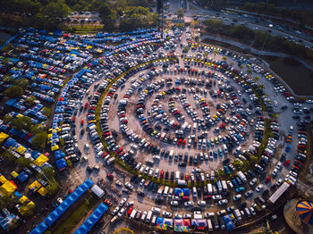 High angle view of illuminated street and car park amidst buildings in city