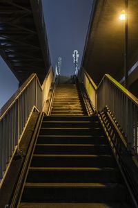 Low angle view of illuminated steps against sky at night