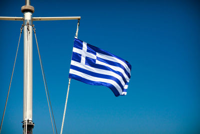 Low angle view of flag against blue sky