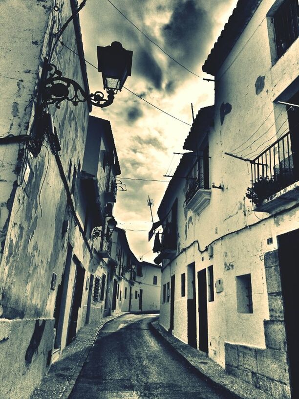 architecture, building exterior, built structure, the way forward, sky, residential structure, residential building, street, diminishing perspective, house, narrow, cloud - sky, building, vanishing point, alley, town, cloud, cobblestone, city, residential district