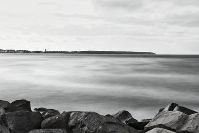 Scenic view of rocks on beach against sky