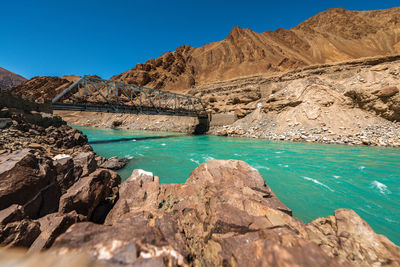 Scenic view of rocks and mountains against blue sky