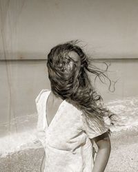 Portrait of young woman standing against sea