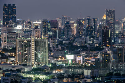 Illuminated cityscape against sky at night