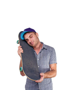 Young man wearing hat standing against white background