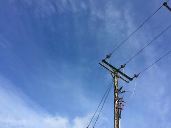 Low angle view of power lines against blue sky