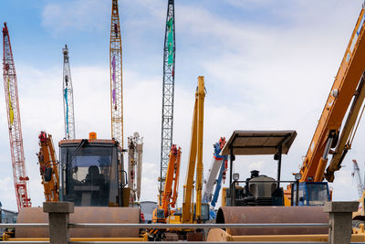 Road roller, mobile crane, and backhoe with long boom. heavy machinery parked at second-hand 