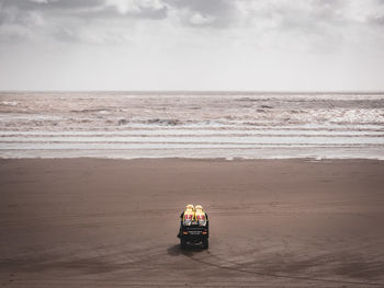 Buggy on sea shore against sky