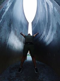 Digital composite image of man standing in tunnel